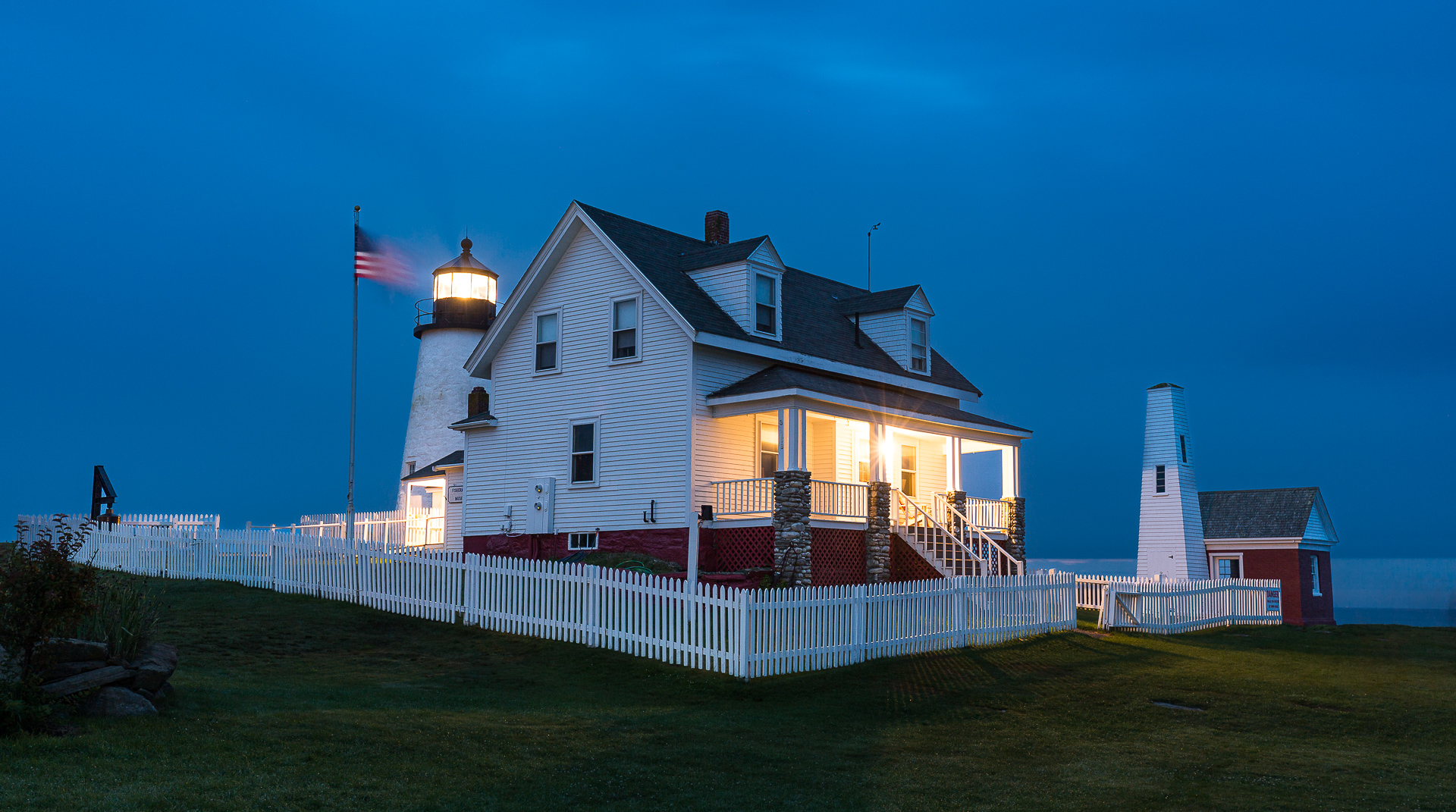 To create this color photo of The Pemaquid Point Lighthouse in Maine, at dawn, a creative exposure technique was used. The camera was placed on a tripod to allow a long exposure. Then, a the photographer painted the fence and buildings with the light from a flashlight.