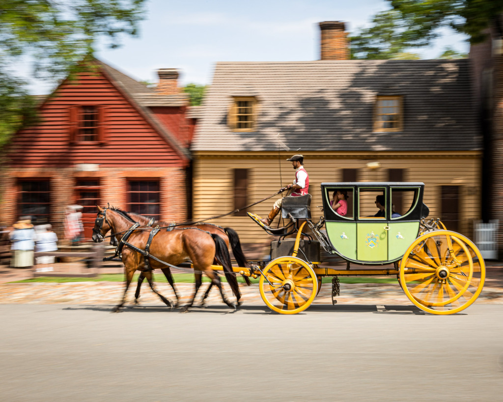 Panning image of horse-drawn carriage in Colonial Williamsburg, Virginia