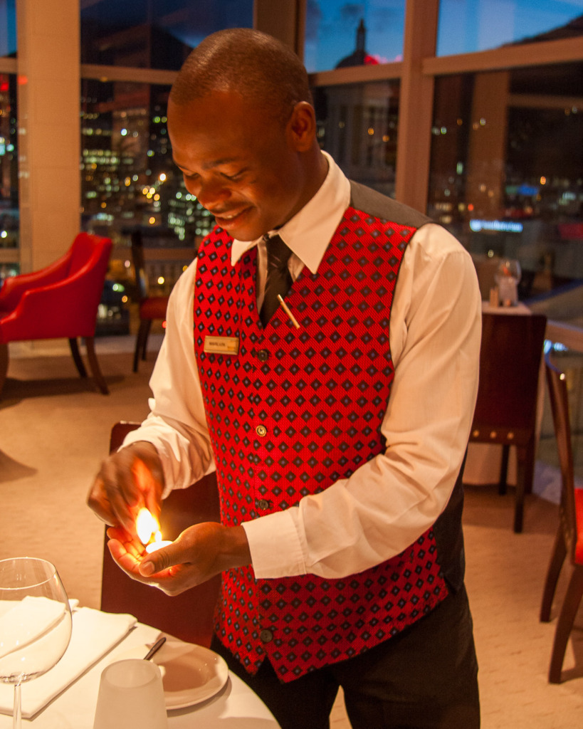Program Mode Photography allows you to capture a waiter in Cape Town lighting a match without the flash going off.