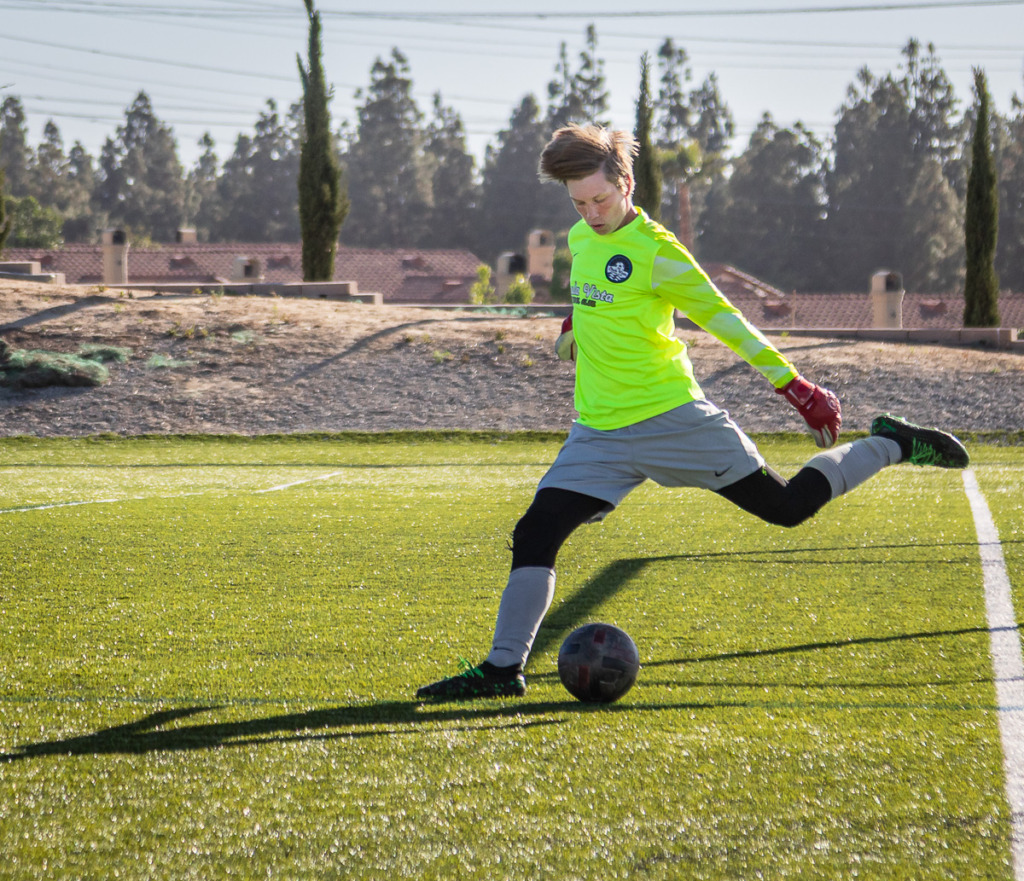 photo of high school soccer player kicking a ball