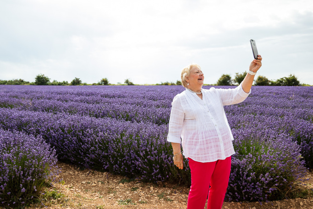 Happy Senior Woman Taking Selfie in Lavender Fields in Provence,