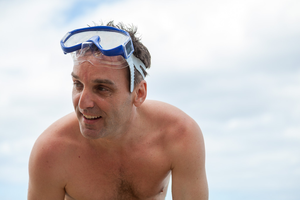An image of a man with a snorkeling mask on his head looking out of the scene.