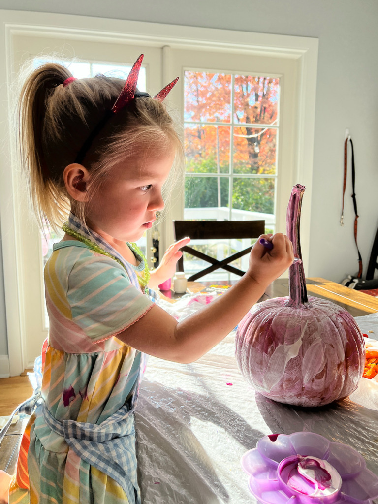 Child painting a pumpkin