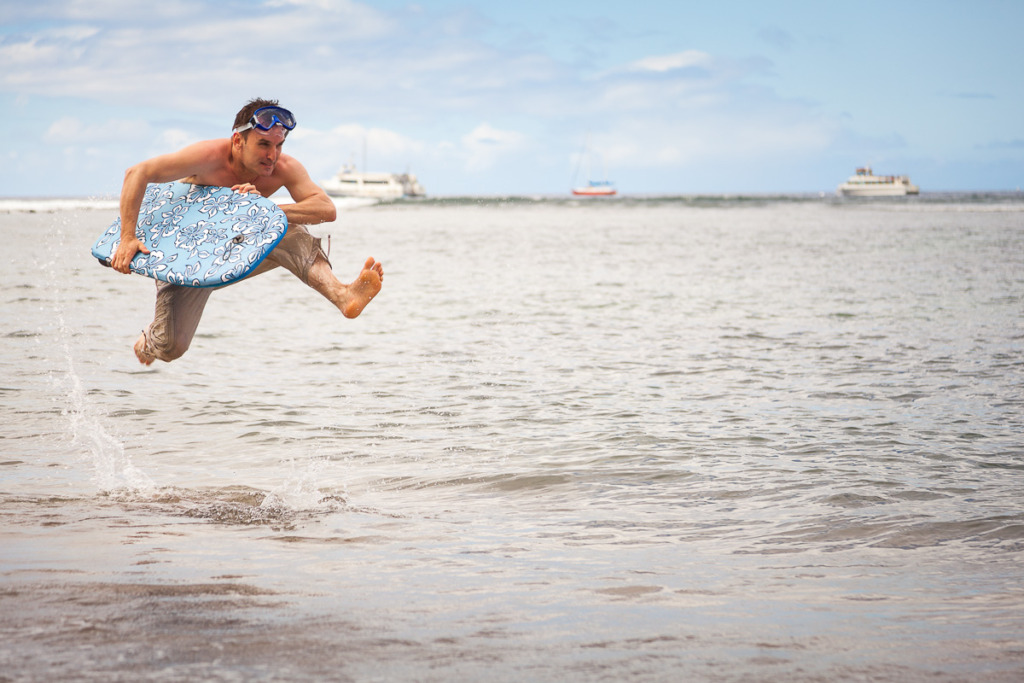 Determined Man Running with His Bodyboard at the Beach. He's Wearing Goggles on His Head.