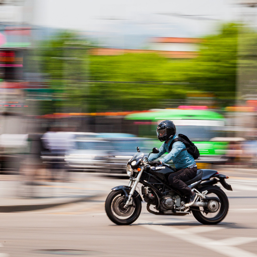3 camera settings for creative control were used to capture this panned image of a motorcycle rider in Seoul