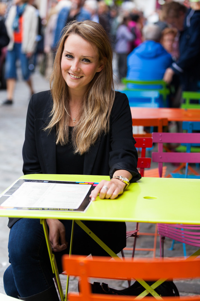 Young Woman at Cafe in Paris with background blurred by understanding how to use aperture mode.